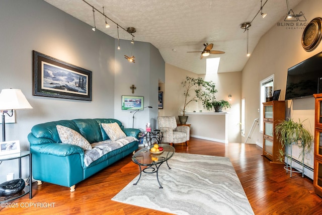 2000 Wenmatt Cir, Anchorage, AK 99517 - living area featuring lofted ceiling, a ceiling fan, track lighting, wood finished floors, and baseboard heating