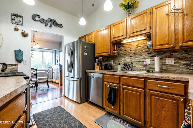 2000 Wenmatt Cir, Anchorage, AK 99517 - kitchen with appliances with stainless steel finishes, decorative backsplash, light wood-type flooring, and light countertops
