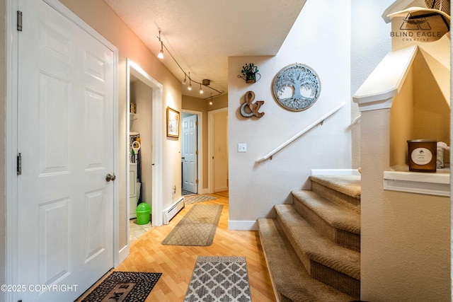 2000 Wenmatt Cir, Anchorage, AK 99517 - entrance foyer featuring a baseboard heating unit, stairs, and wood finished floors