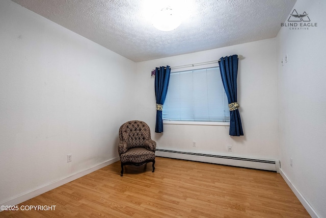 2000 Wenmatt Cir, Anchorage, AK 99517 - unfurnished room with a baseboard heating unit, wood finished floors, and a textured ceiling