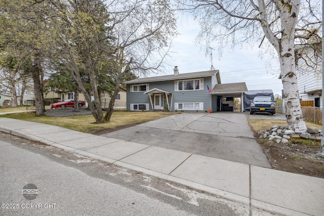 1851 E 53rd Ave, Anchorage, AK 99507 - split foyer home with fence, an attached carport, a front yard, a chimney, and driveway