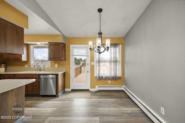 1851 E 53rd Ave, Anchorage, AK 99507 - kitchen featuring light countertops, a baseboard heating unit, a sink, dishwasher, and a notable chandelier