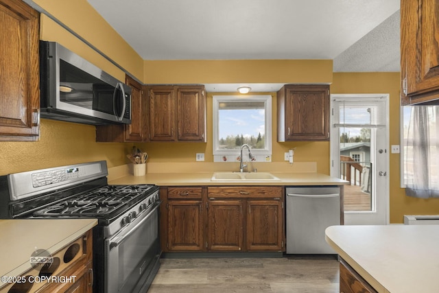 1851 E 53rd Ave, Anchorage, AK 99507 - kitchen with light countertops, appliances with stainless steel finishes, a sink, and light wood-type flooring