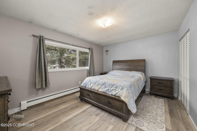 1851 E 53rd Ave, Anchorage, AK 99507 - bedroom with baseboards, a textured ceiling, baseboard heating, and wood finished floors