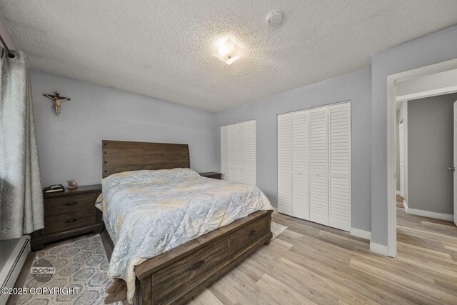1851 E 53rd Ave, Anchorage, AK 99507 - bedroom with baseboards, a baseboard radiator, light wood-style flooring, and a textured ceiling