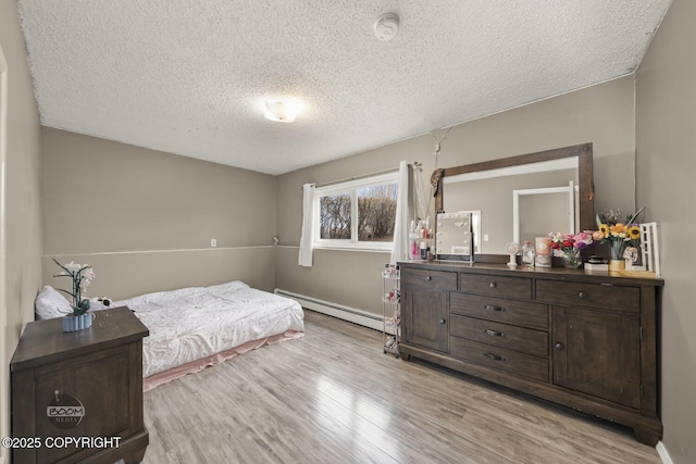 1851 E 53rd Ave, Anchorage, AK 99507 - bedroom with light wood-style floors, a textured ceiling, and a baseboard heating unit