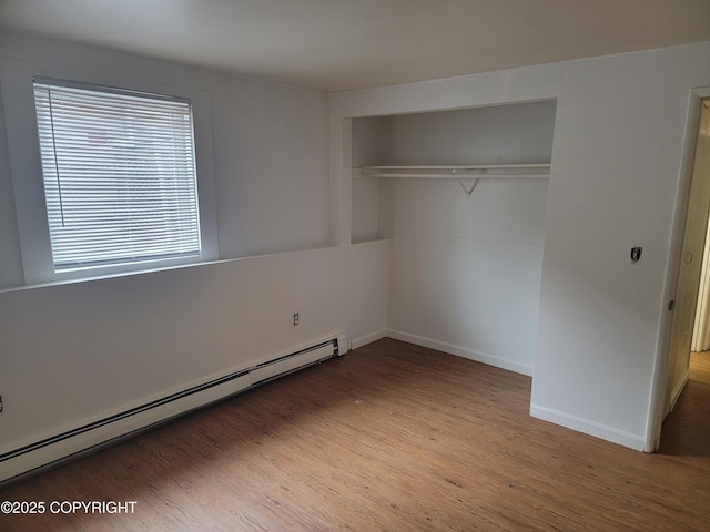 3505 Iowa St, Anchorage, AK 99517 - unfurnished bedroom featuring a closet, baseboards, light wood-style flooring, and baseboard heating