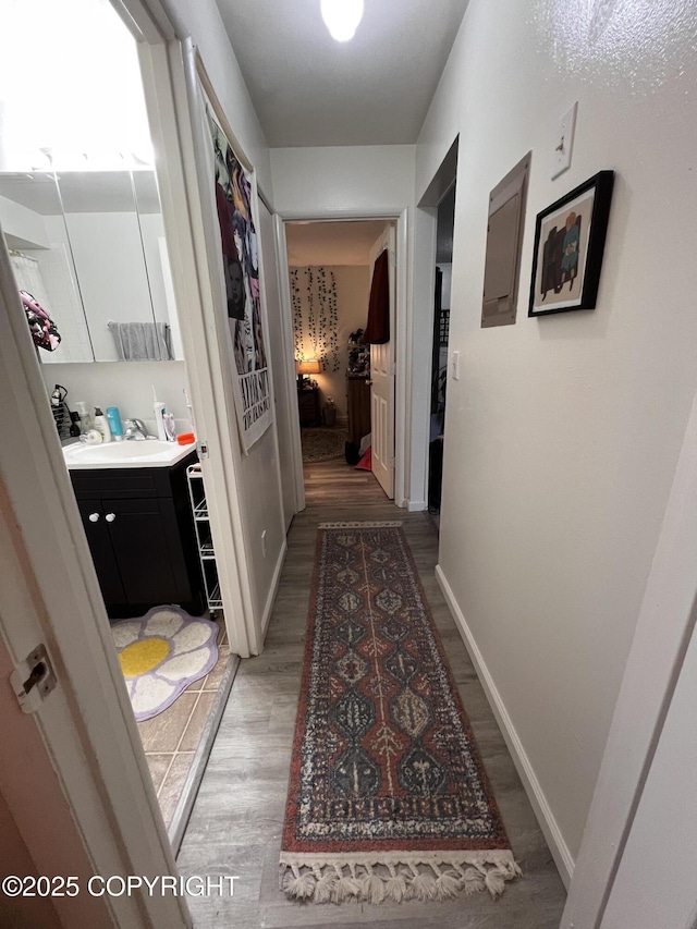 3505 Iowa St, Anchorage, AK 99517 - corridor featuring a sink, baseboards, and light wood-type flooring