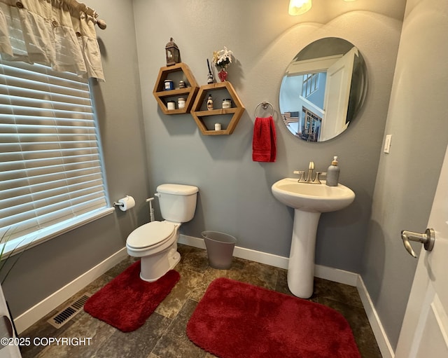 bathroom with toilet, baseboards, and visible vents