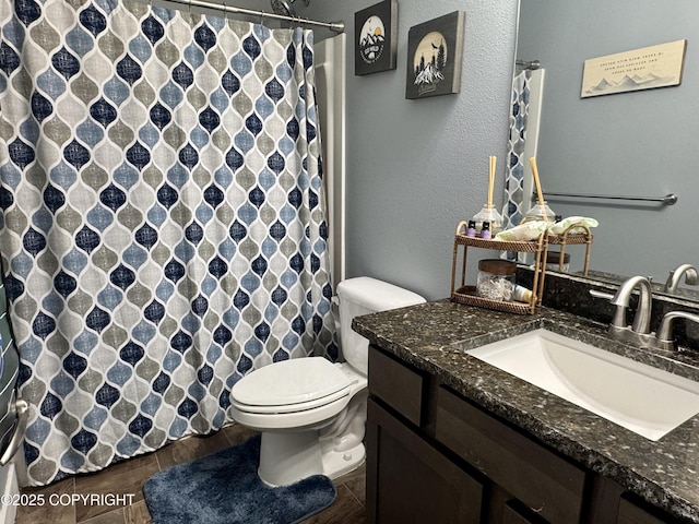 bathroom with toilet, curtained shower, wood finished floors, and vanity