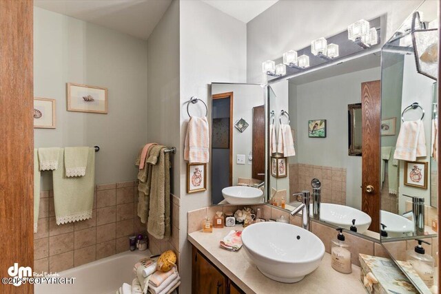 full bath with vanity and a tub