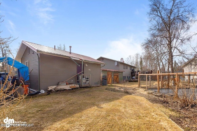 back of property with a lawn and metal roof