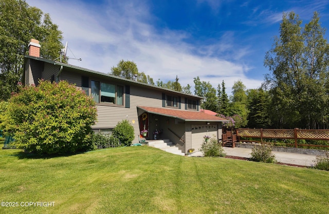 104 Beech Ave, Kenai, AK 99611 - rear view of property with a chimney, a garage, and concrete driveway