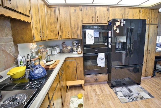 104 Beech Ave, Kenai, AK 99611 - kitchen featuring black appliances, light countertops, light wood finished floors, and brown cabinets