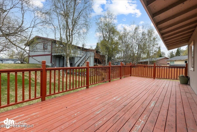 deck featuring a yard and stairway