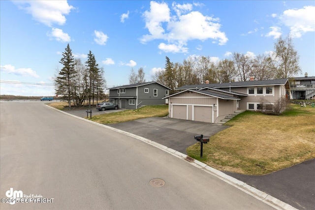 view of front of home featuring an attached garage, driveway, and a front lawn