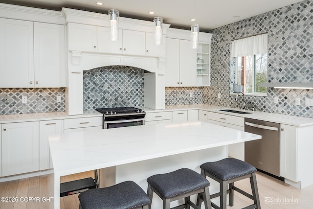 3030 E Sandman Cir, Wasilla, AK 99654 - kitchen featuring appliances with stainless steel finishes, a sink, light wood-type flooring, a kitchen bar, and recessed lighting