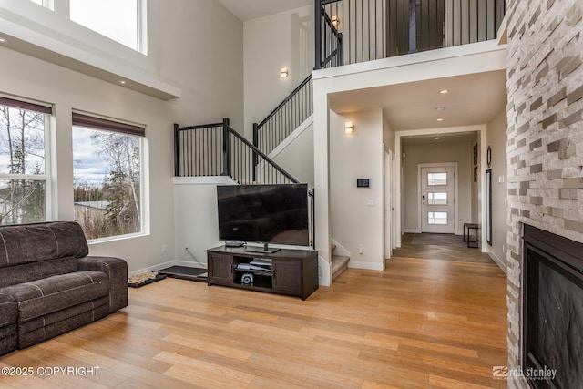 3030 E Sandman Cir, Wasilla, AK 99654 - living area with stairs, a high ceiling, light wood-type flooring, baseboards, and a fireplace