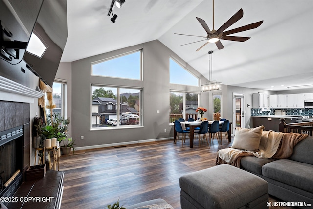 800 Howard Cir, Anchorage, AK 99504 - living room featuring a tiled fireplace, ceiling fan, plenty of natural light, dark wood-type flooring, and high vaulted ceiling