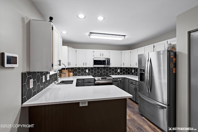 800 Howard Cir, Anchorage, AK 99504 - kitchen featuring stainless steel appliances, a peninsula, tasteful backsplash, dark wood finished floors, and recessed lighting