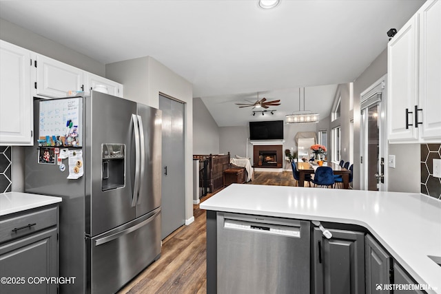 800 Howard Cir, Anchorage, AK 99504 - kitchen with appliances with stainless steel finishes, ceiling fan, backsplash, and a warm lit fireplace