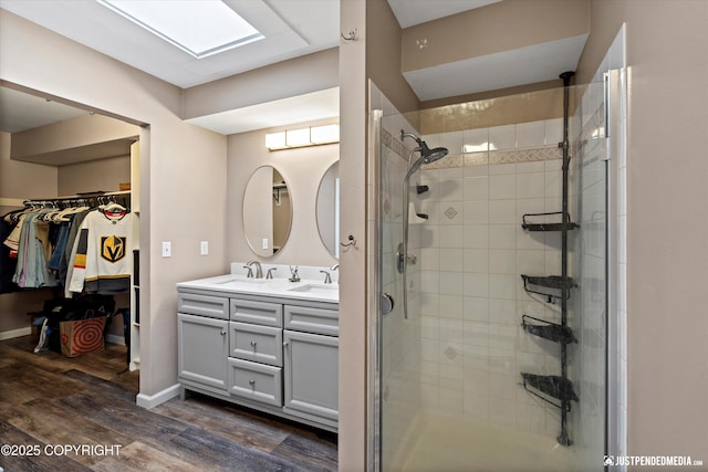 800 Howard Cir, Anchorage, AK 99504 - full bathroom featuring a shower stall, double vanity, wood finished floors, a walk in closet, and baseboards