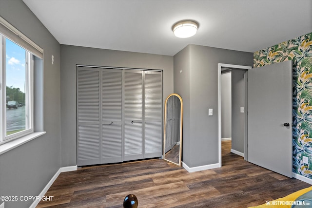 800 Howard Cir, Anchorage, AK 99504 - unfurnished bedroom featuring wood finished floors, baseboards, a closet, multiple windows, and wallpapered walls