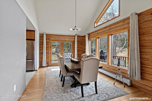 3915 Hiland Rd, Eagle River, AK 99577 - dining space featuring a baseboard radiator, log walls, french doors, light wood-style flooring, and high vaulted ceiling