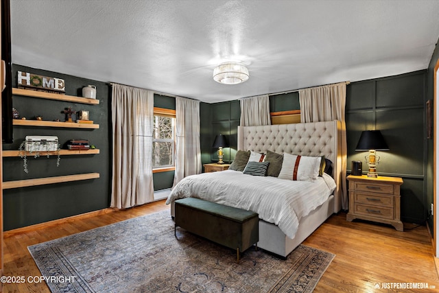 3915 Hiland Rd, Eagle River, AK 99577 - bedroom with light wood-style floors, a textured ceiling, and a baseboard radiator