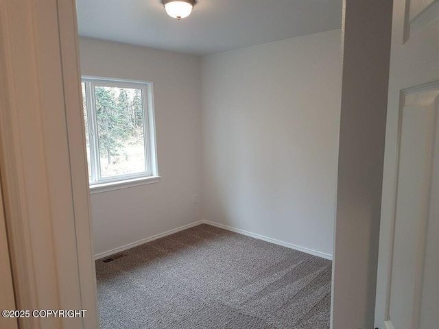 carpeted empty room featuring baseboards and visible vents