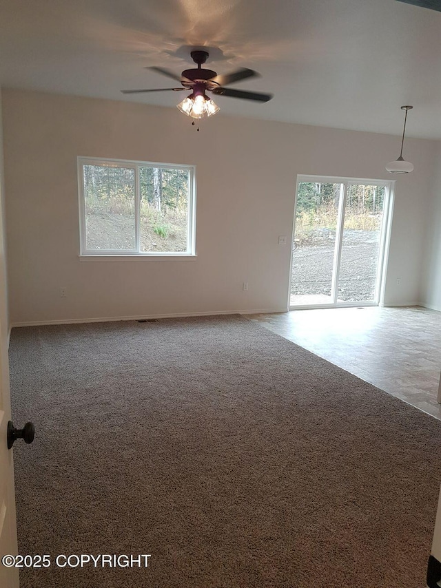 spare room with carpet floors, ceiling fan, and a healthy amount of sunlight