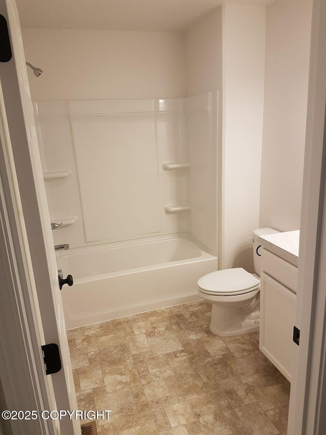 full bath with bathing tub / shower combination, vanity, toilet, and stone finish flooring