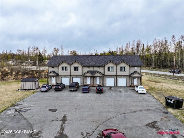 view of front of property with driveway, an outbuilding, a shed, and a garage