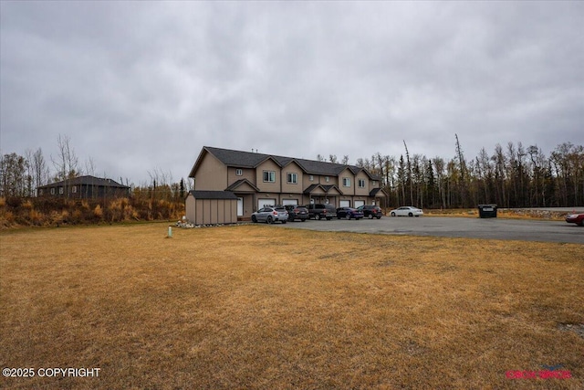 view of front of home with uncovered parking and a front lawn