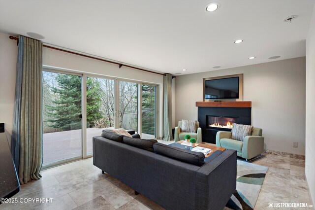 living room with recessed lighting and a glass covered fireplace