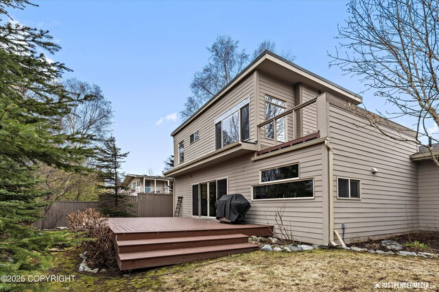 back of house with fence and a wooden deck