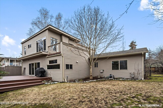rear view of house featuring a deck and fence