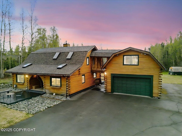 17720 Werre St, Chugiak, AK 99567 - log home featuring log exterior, a gambrel roof, a chimney, asphalt driveway, and an attached garage