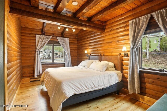 17720 Werre St, Chugiak, AK 99567 - bedroom featuring hardwood / wood-style floors, beamed ceiling, wood ceiling, and rustic walls