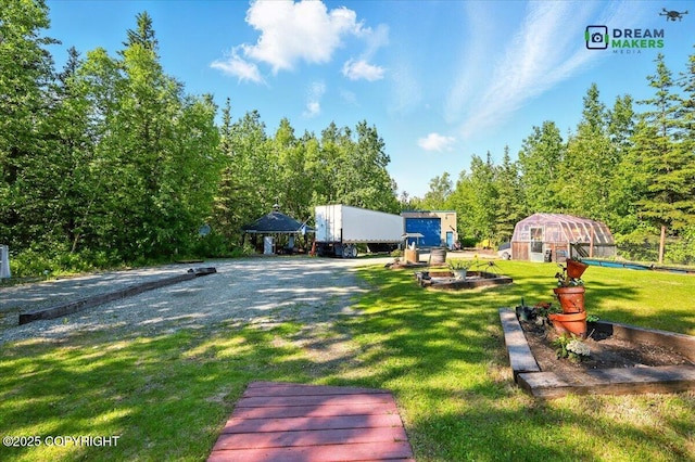 1900 N Green Forest Dr, Palmer, AK 99645 - rear view of house with a lawn, an outbuilding, and a greenhouse