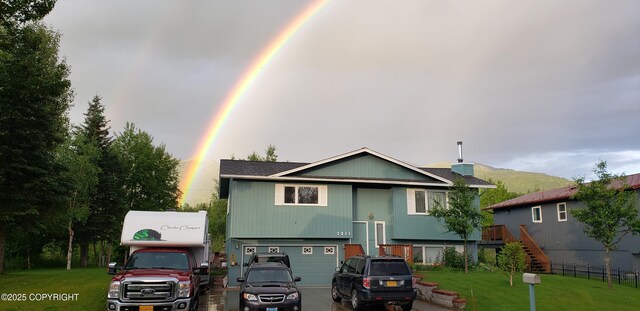3211 Shamrock St, Anchorage, AK 99504 - back of house featuring stairway, an attached garage, and a yard