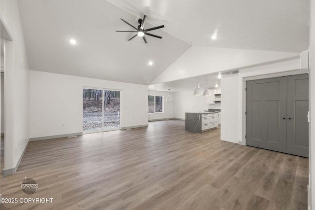 7177 N Paw St, Wasilla, AK 99654 - unfurnished living room with high vaulted ceiling, a ceiling fan, recessed lighting, baseboards, and light wood-type flooring