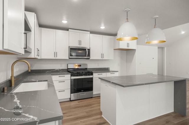 7177 N Paw St, Wasilla, AK 99654 - kitchen with white cabinetry, appliances with stainless steel finishes, a sink, and light wood-style floors