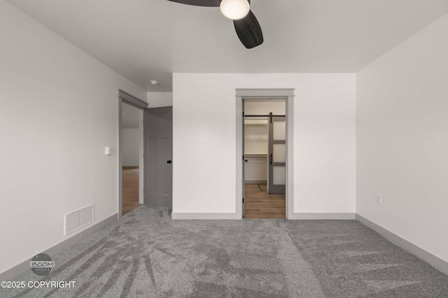 7177 N Paw St, Wasilla, AK 99654 - unfurnished bedroom featuring visible vents, baseboards, ceiling fan, a walk in closet, and carpet
