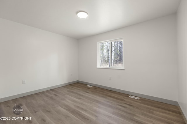 7177 N Paw St, Wasilla, AK 99654 - empty room with baseboards, visible vents, and wood finished floors