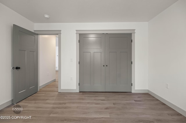 7177 N Paw St, Wasilla, AK 99654 - unfurnished bedroom featuring baseboards, a closet, and light wood-type flooring