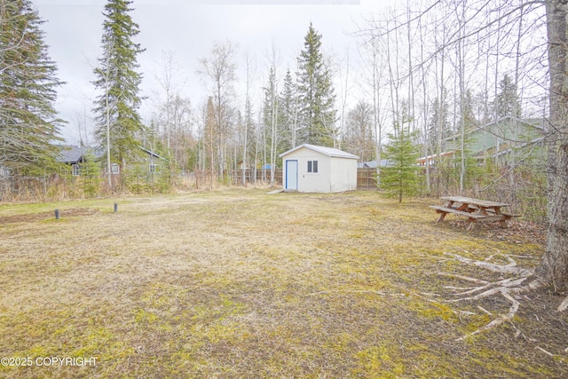 view of yard featuring an outdoor structure, fence, and a storage unit