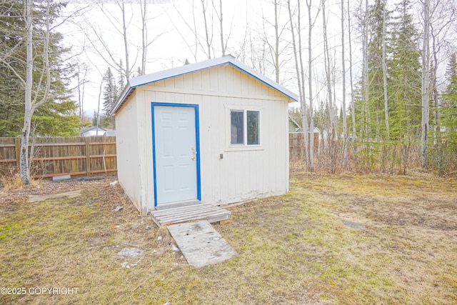 view of outbuilding with fence and an outbuilding