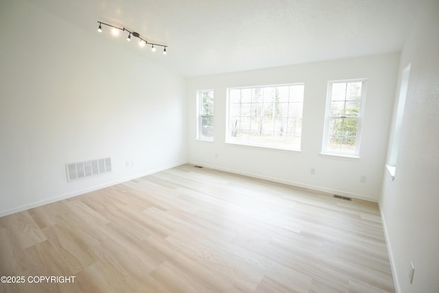 spare room with baseboards, visible vents, and a wealth of natural light