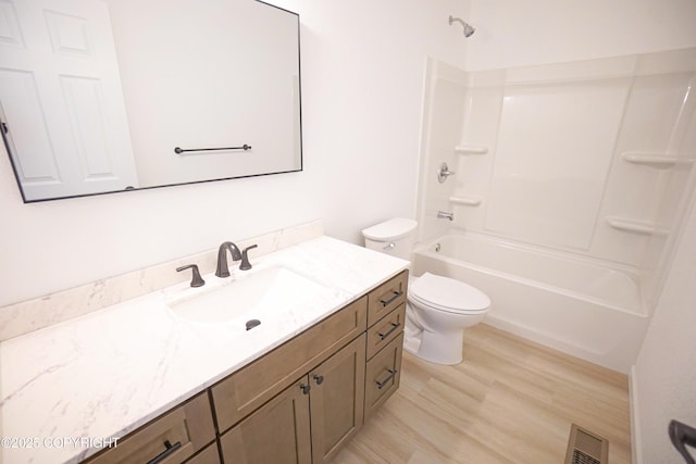 bathroom featuring vanity, toilet, tub / shower combination, wood finished floors, and visible vents